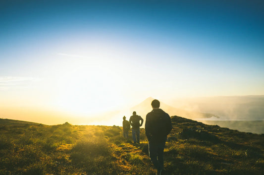Three people spending time outdoors with sun and hiking