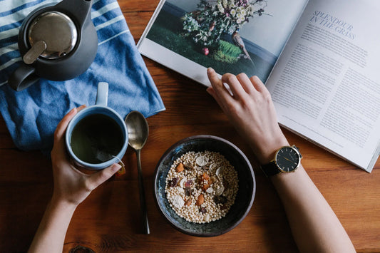 Table with book, morning mug, and bowl of healthy grains and dried fruits-morning rituals for energy